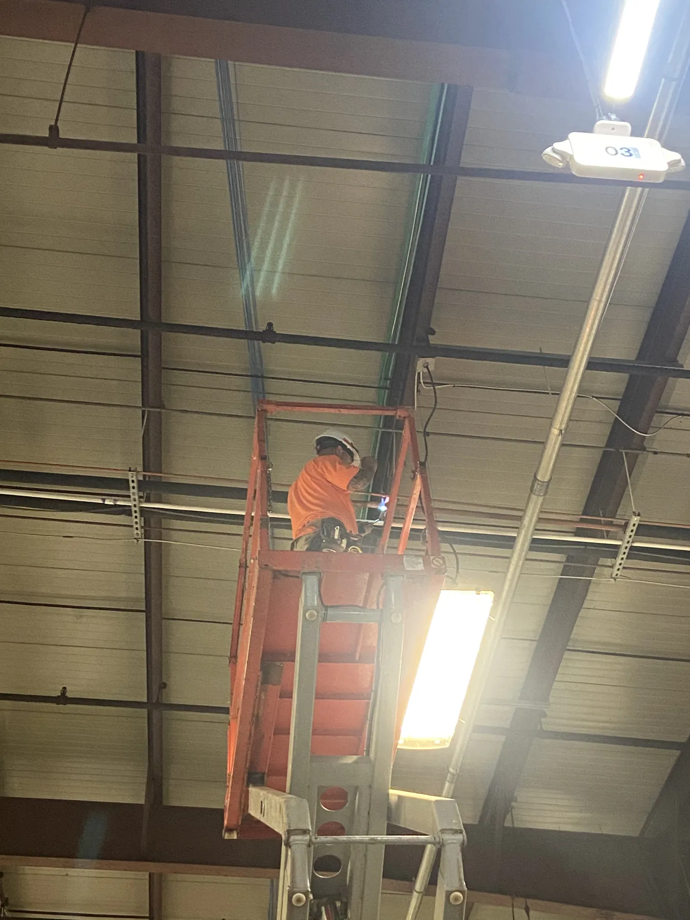 Technician on a lift performing overhead industrial work